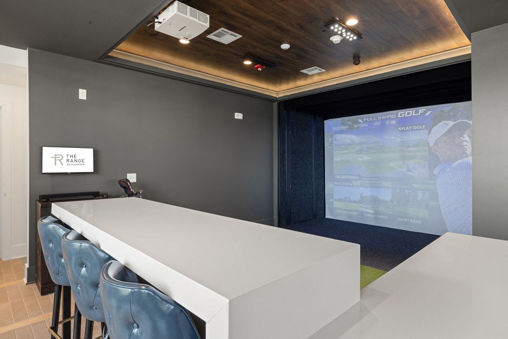 a game simulator room with a table and chairs and a projector screen