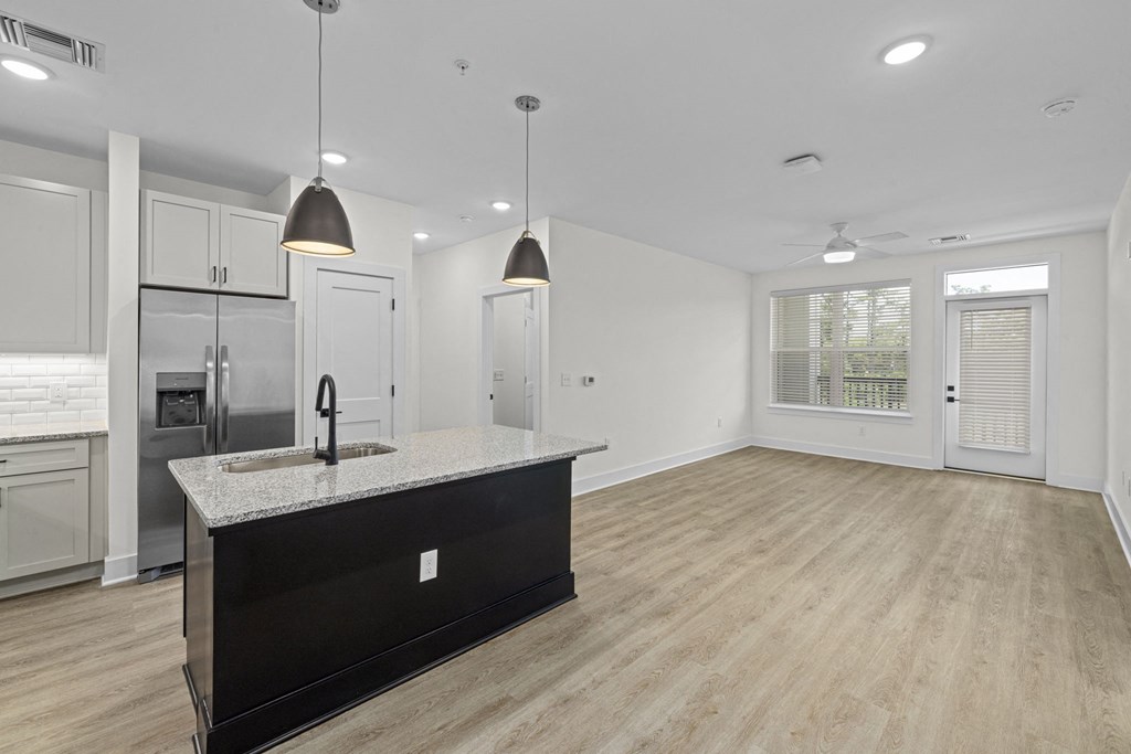 the kitchen and living room in a new home with white cabinets and a large island