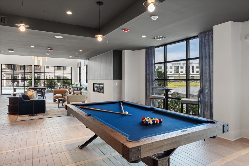 A pool table in a room with a view of the outside.