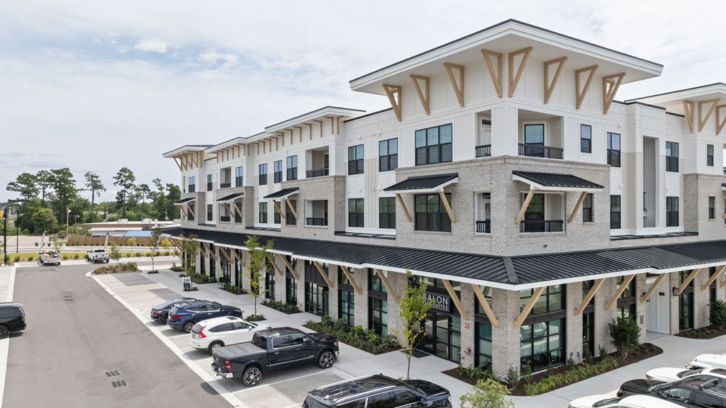 a large apartment building with cars parked in front of it
