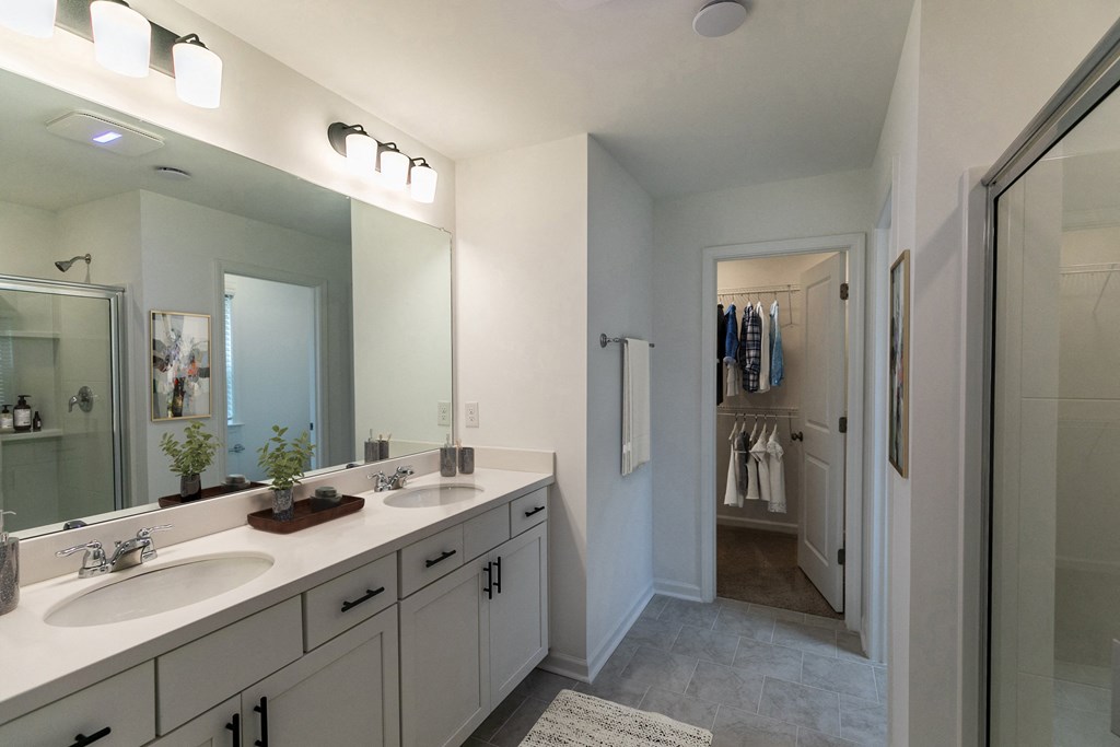 a bathroom with two sinks and a walk in shower