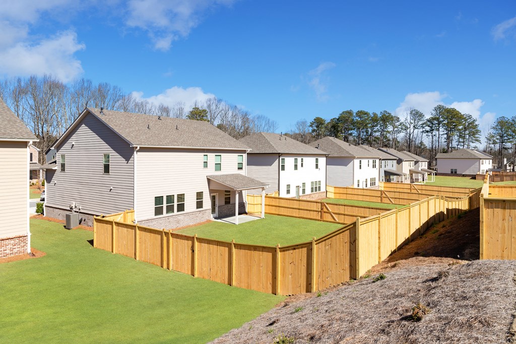 a wooden fence around a yard in front of houses
