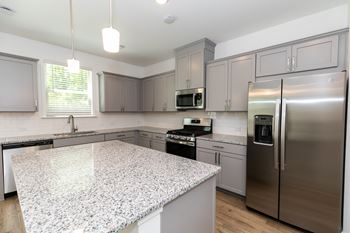 a kitchen with a large island and stainless steel appliances