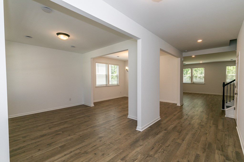 a large living room with hardwood floors and white walls
