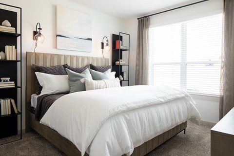 a bedroom with white walls and a large bed with a wooden headboard