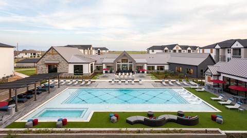 a large pool with lounge chairs in front of a building