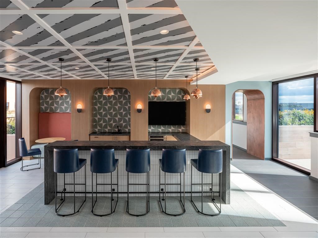 a large kitchen with a bar and chairs