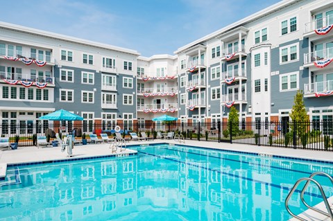 a swimming pool with an apartment building in the background
