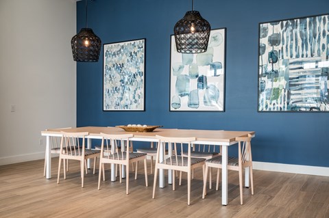 a dining room with blue walls and a white table and chairs