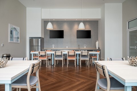 a dining room with tables and chairs and a kitchen