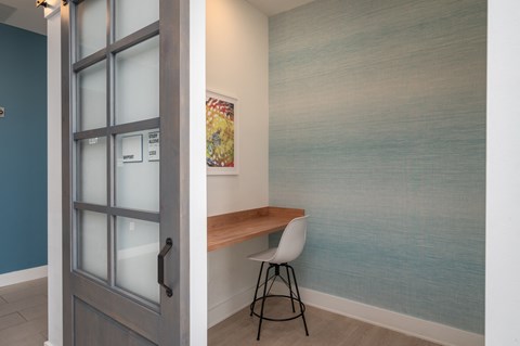a desk with a chair in a room with a glass door