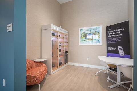 a patient room with a table and a chair and a refrigerator