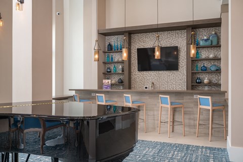 a lobby with a bar and chairs and a television