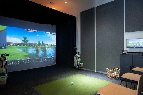 a living room with a golf simulator and a large screen tv