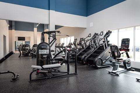 a fitness room with cardio machines and weights
