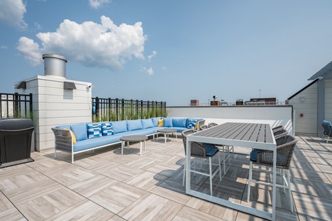 a rooftop patio with couches and a table