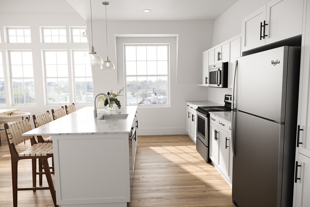 a white kitchen with stainless steel appliances and a white island