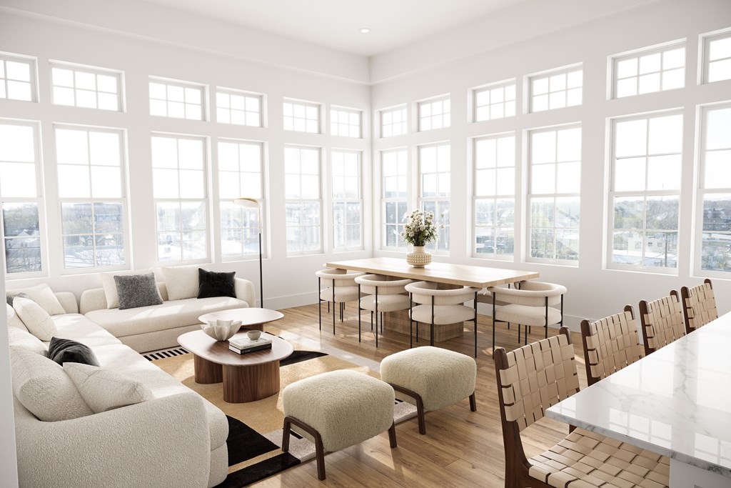 a living room with a large group of windows and a table and chairs