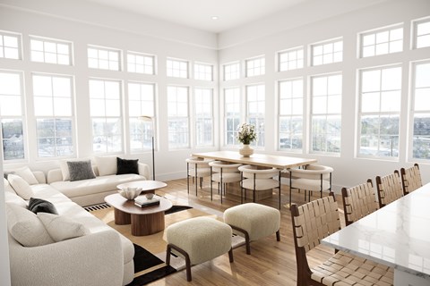 a living room with a large group of windows and a table and chairs