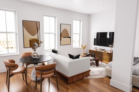 A living room with a white couch, a black table, and a television.