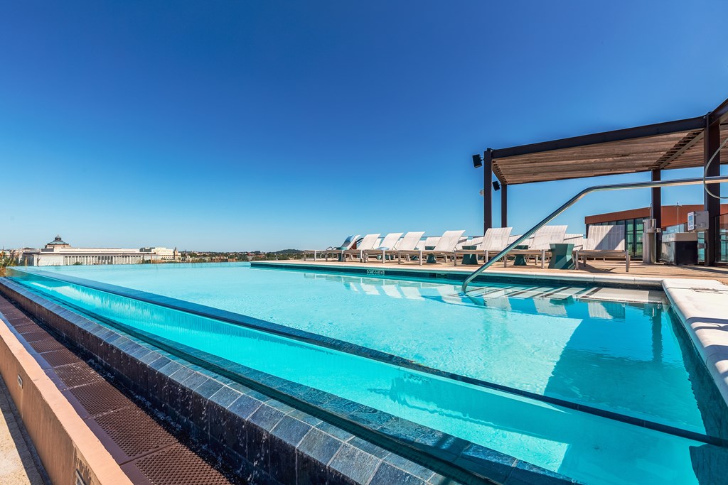 A long rectangular swimming pool with a metal railing.