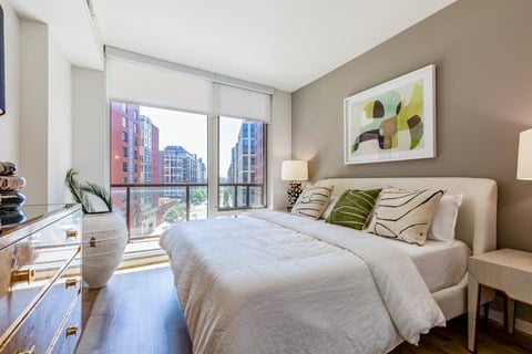 A bedroom with a large bed and a view of the city.
