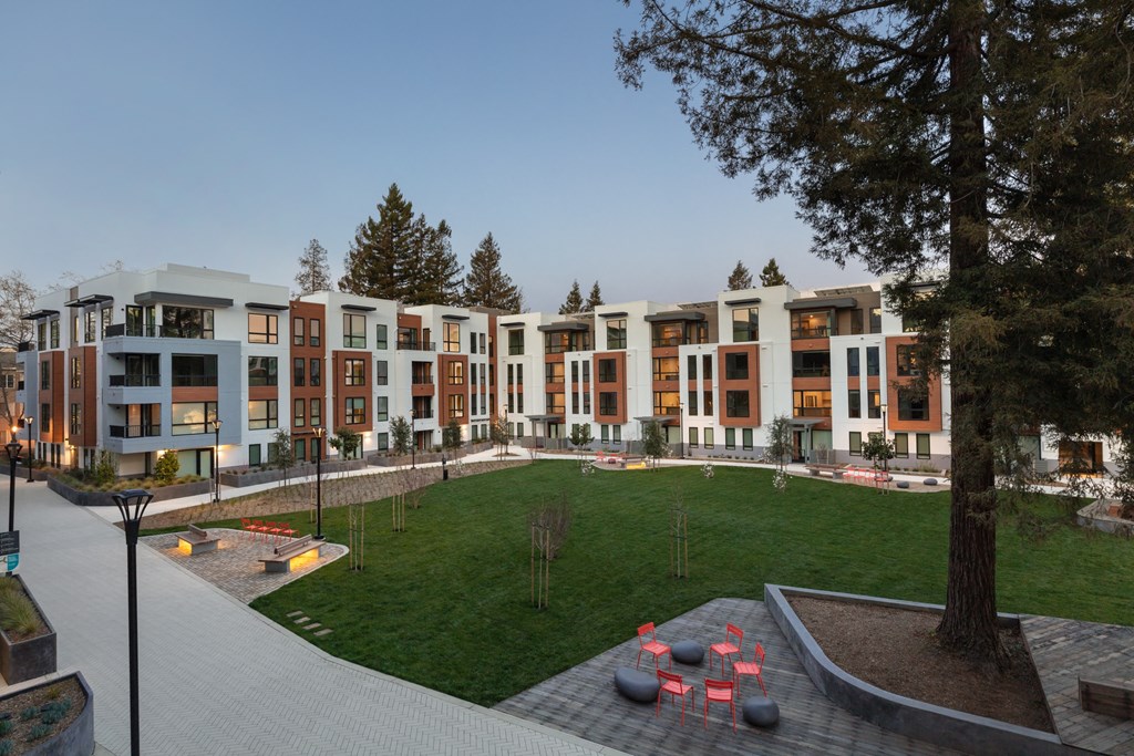 a row of apartment buildings with a grassy area in front of them