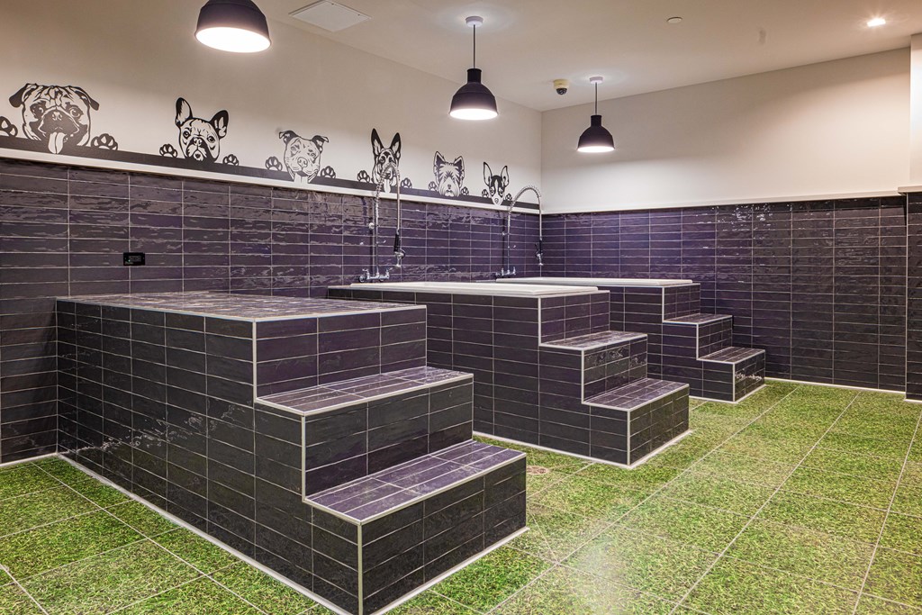 a large bathroom with green grass on the floor and black tiles on the walls