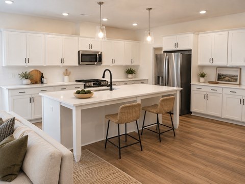 A modern kitchen with white cabinets and a large island.