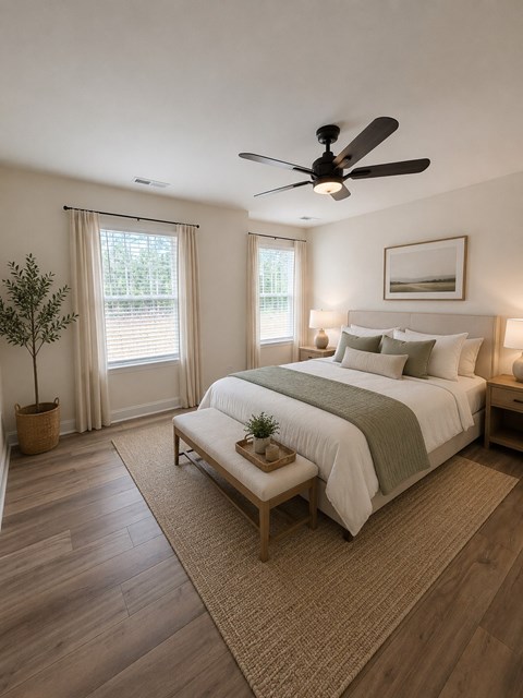 A bedroom with a large bed, a ceiling fan, and a small potted plant.
