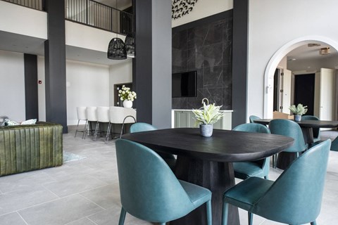 a dining room with blue chairs and a black table