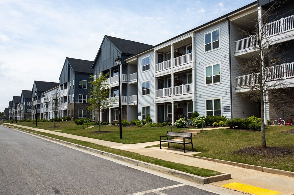 a row of apartment buildings on the side of a street