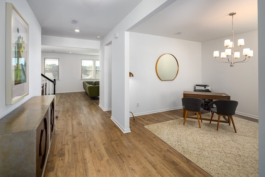 a dining room and living room with white walls and wood floors