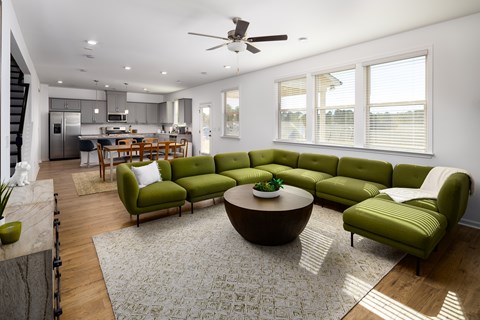 a living room with green couches and a round table