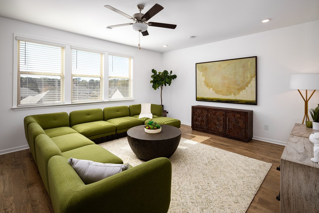 a living room with green couches and a round coffee table
