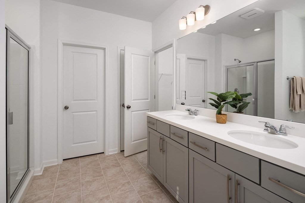 a bathroom with two sinks and a mirror and a shower