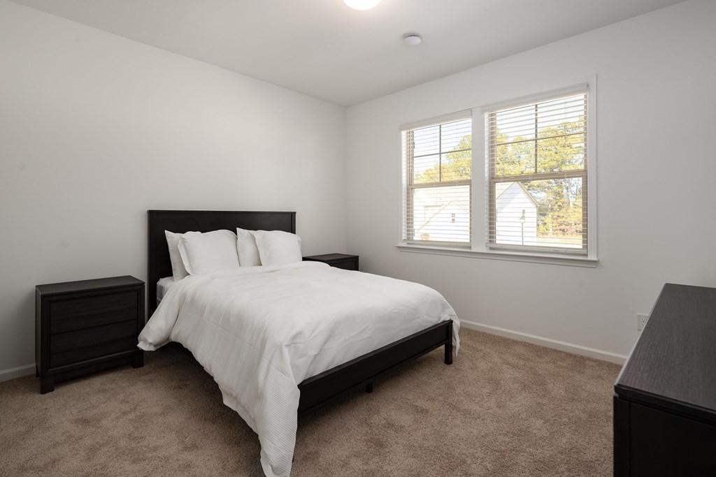 an empty bedroom with a bed and a window