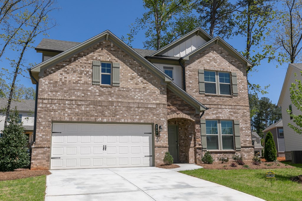 a home with a brick facade and a white garage door