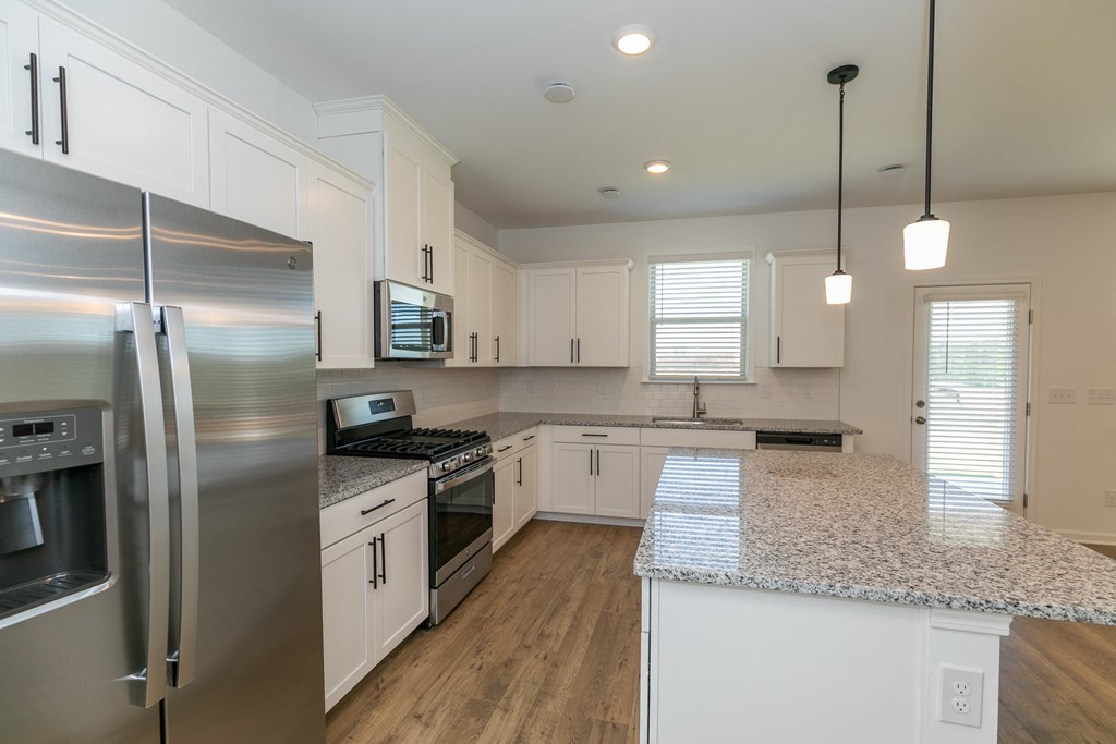 a kitchen with white cabinets and a granite counter top