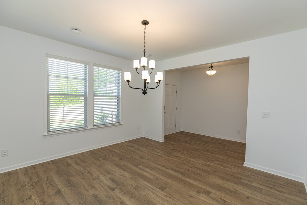 an empty dining room with a chandelier