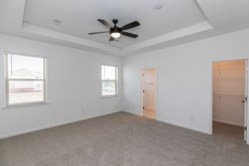 a bedroom with white walls and a ceiling fan