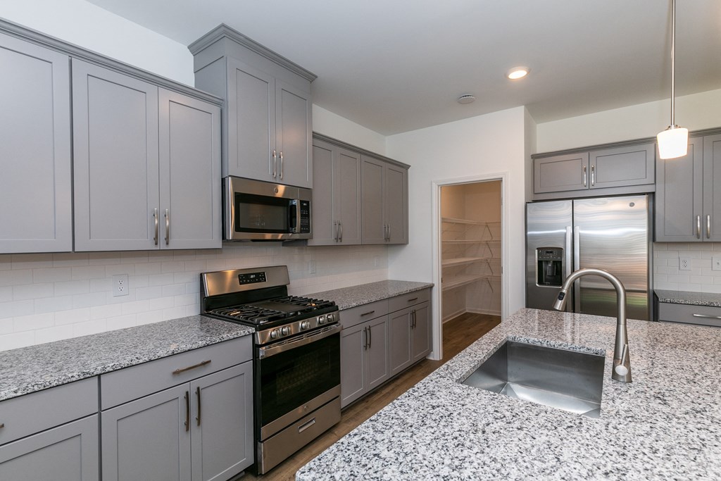 a kitchen with gray cabinets and granite countertops