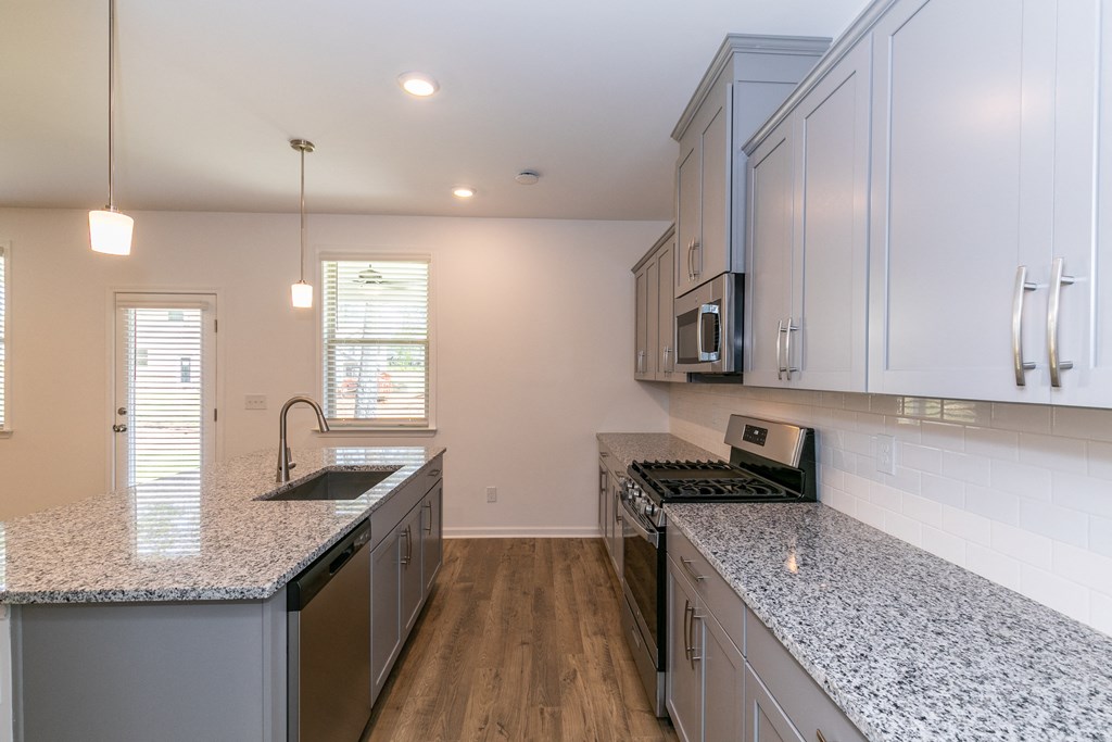 a kitchen with white cabinets and granite countertops