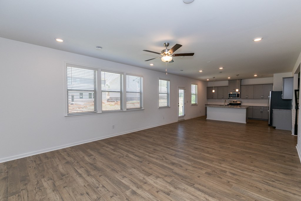 a living room with hardwood floors and a ceiling fan