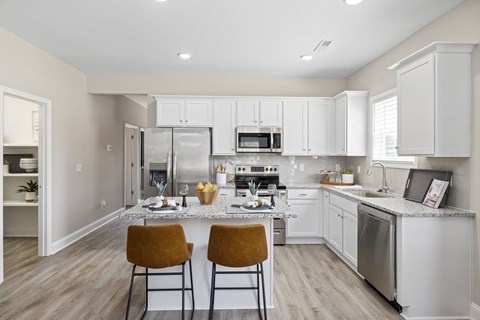 A kitchen with white cabinets and a granite countertop.