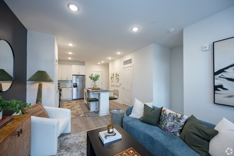a living room and kitchen with a blue couch and a table