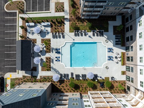 an aerial view of a swimming pool on the roof of a tall building