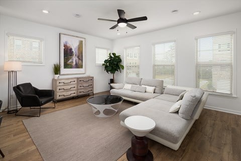 a living room with a couch and a chair and a ceiling fan