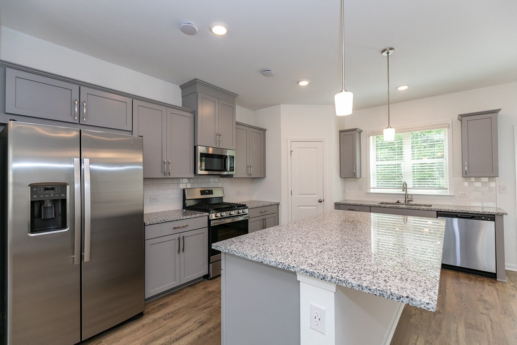 a kitchen with a large island and stainless steel appliances