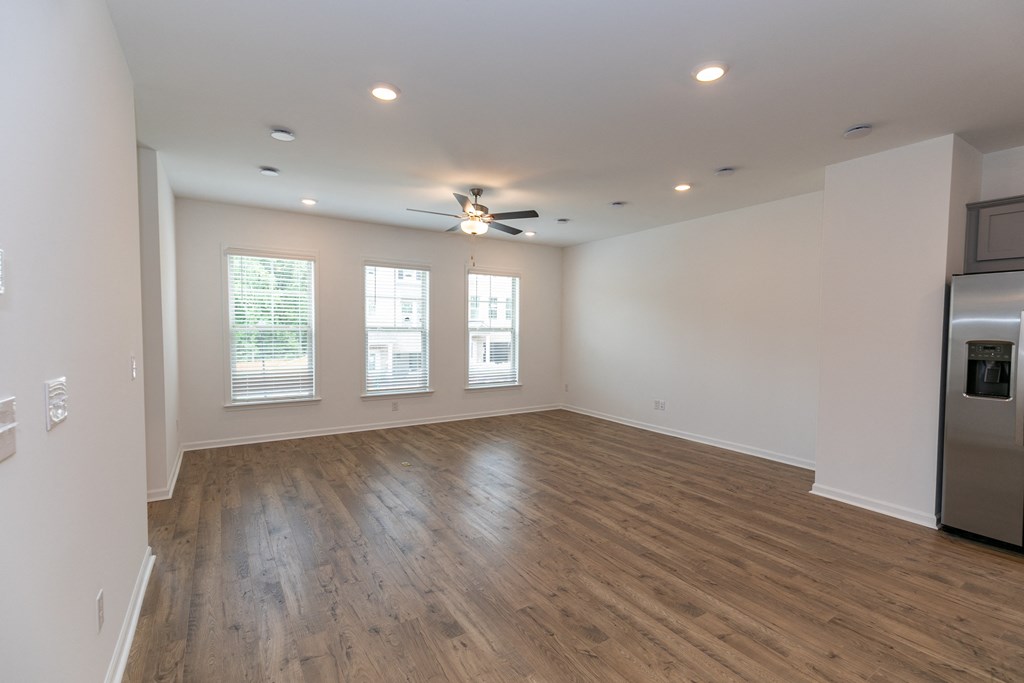 a living room with hardwood floors and a ceiling fan